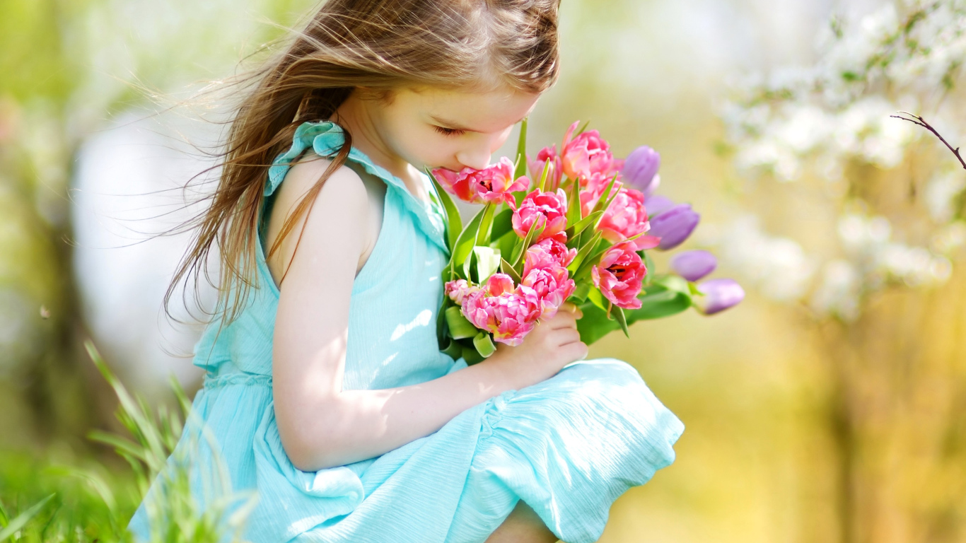 Красивая девочка в голубом платье с букетом тюльпанов