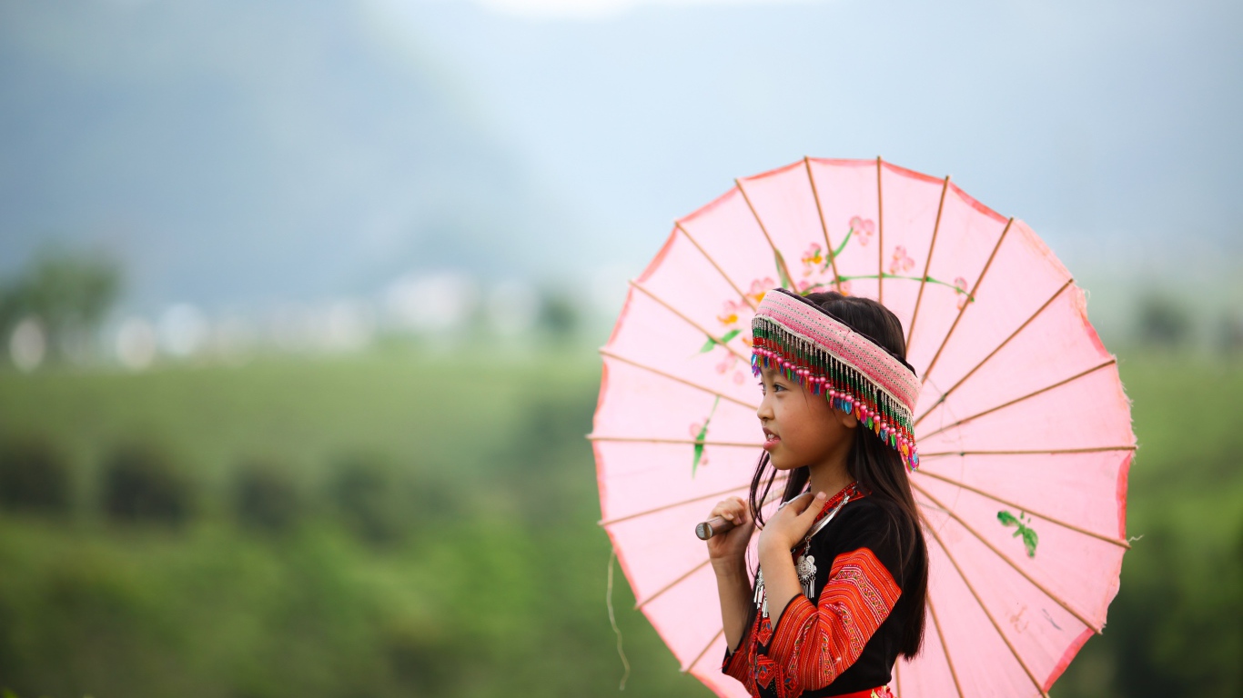 Маленькая девочка азиатка в розовым зонтом