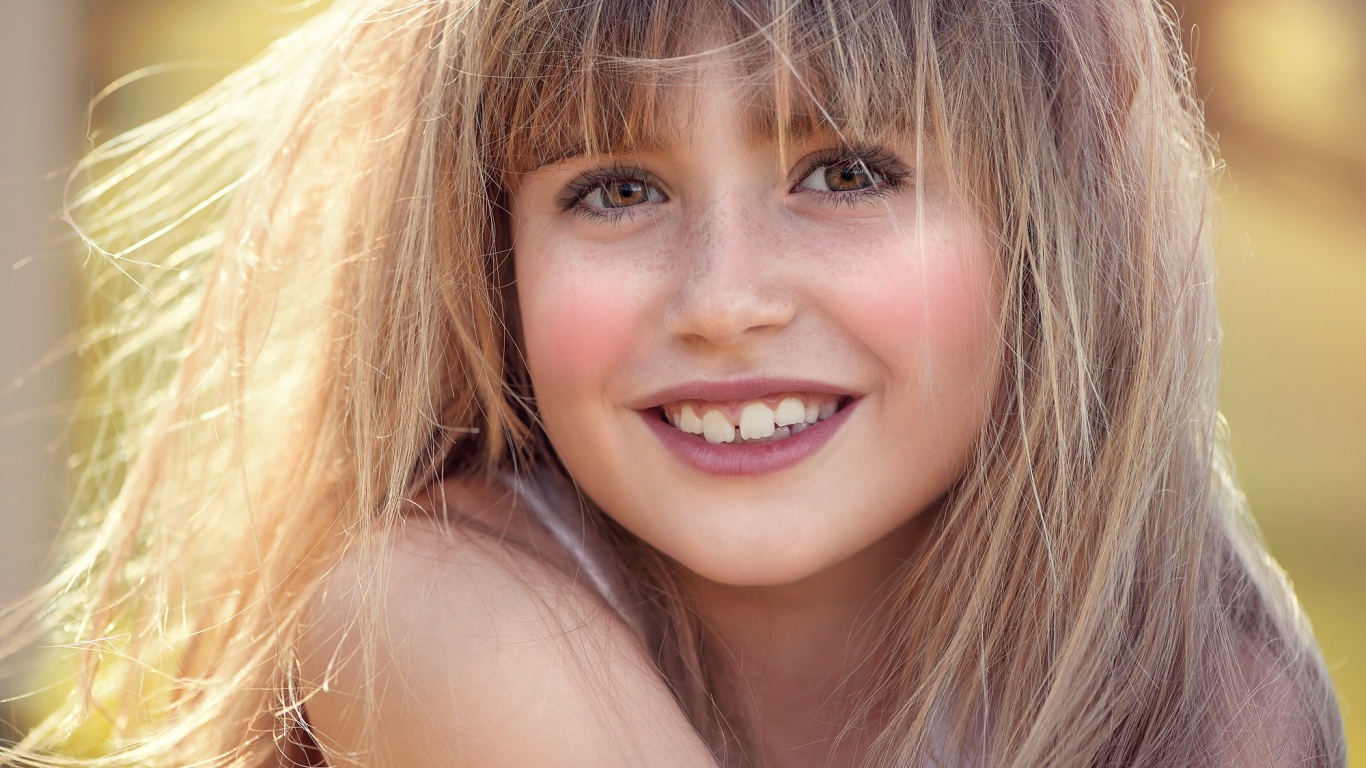 Улыбающаяся девочка с веснушками на лице 