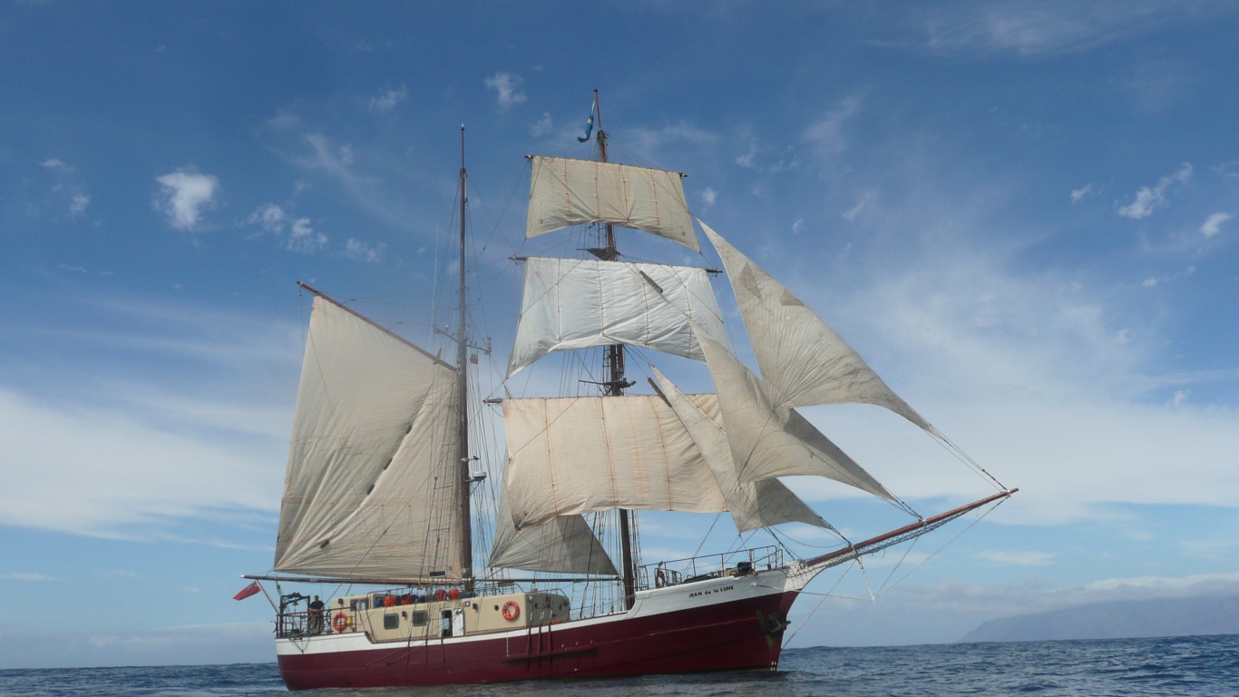 Больше судно с белыми парусами в море 