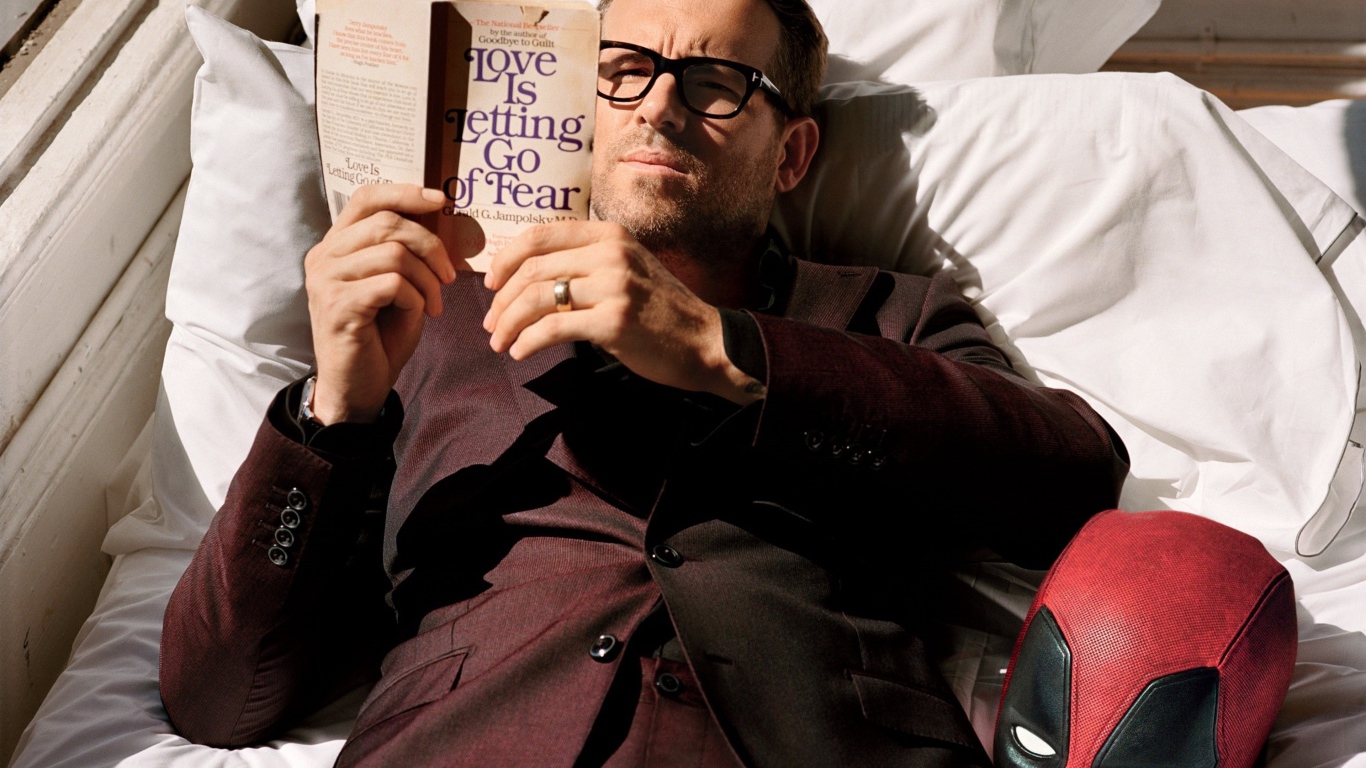 Актер Райан Рейнольдс лежит с книгой на кровати