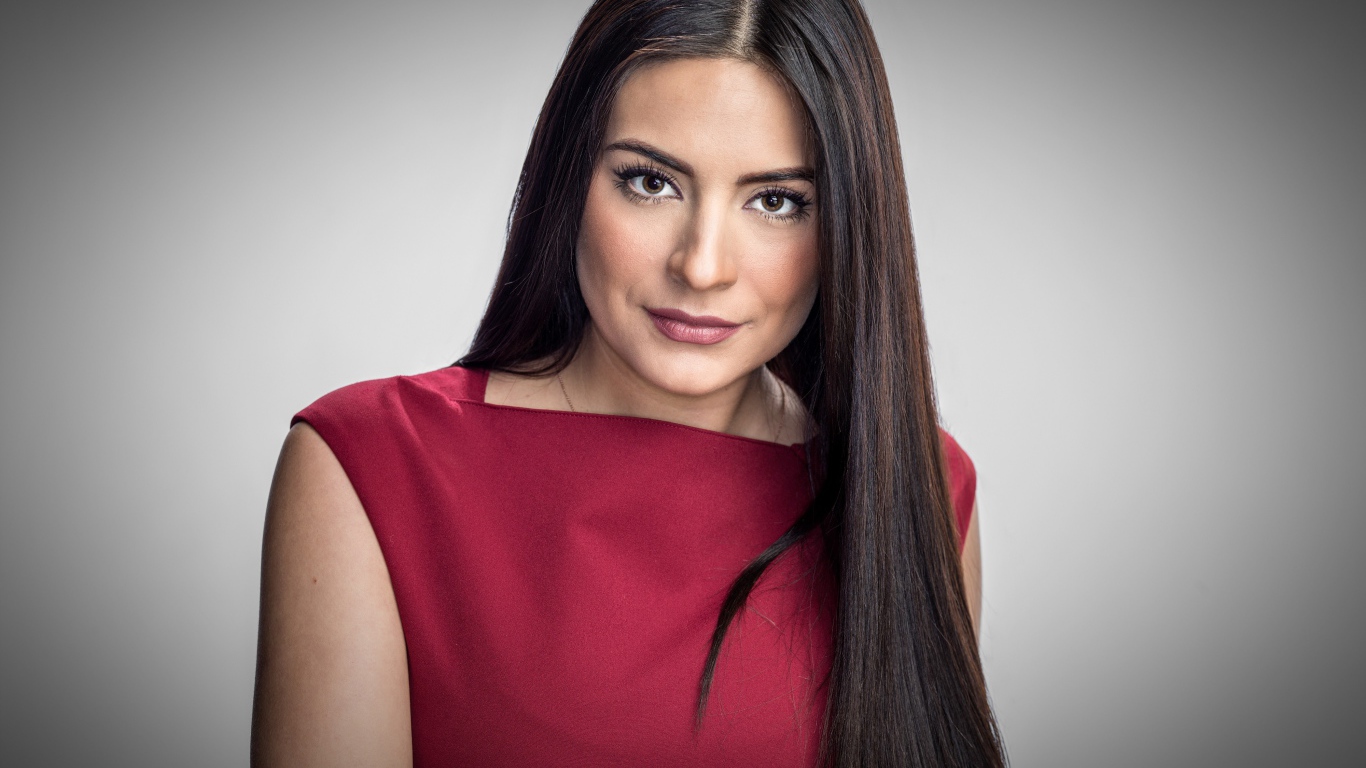 Актриса Ана Бренда Контрерас в красном платье на сером фоне