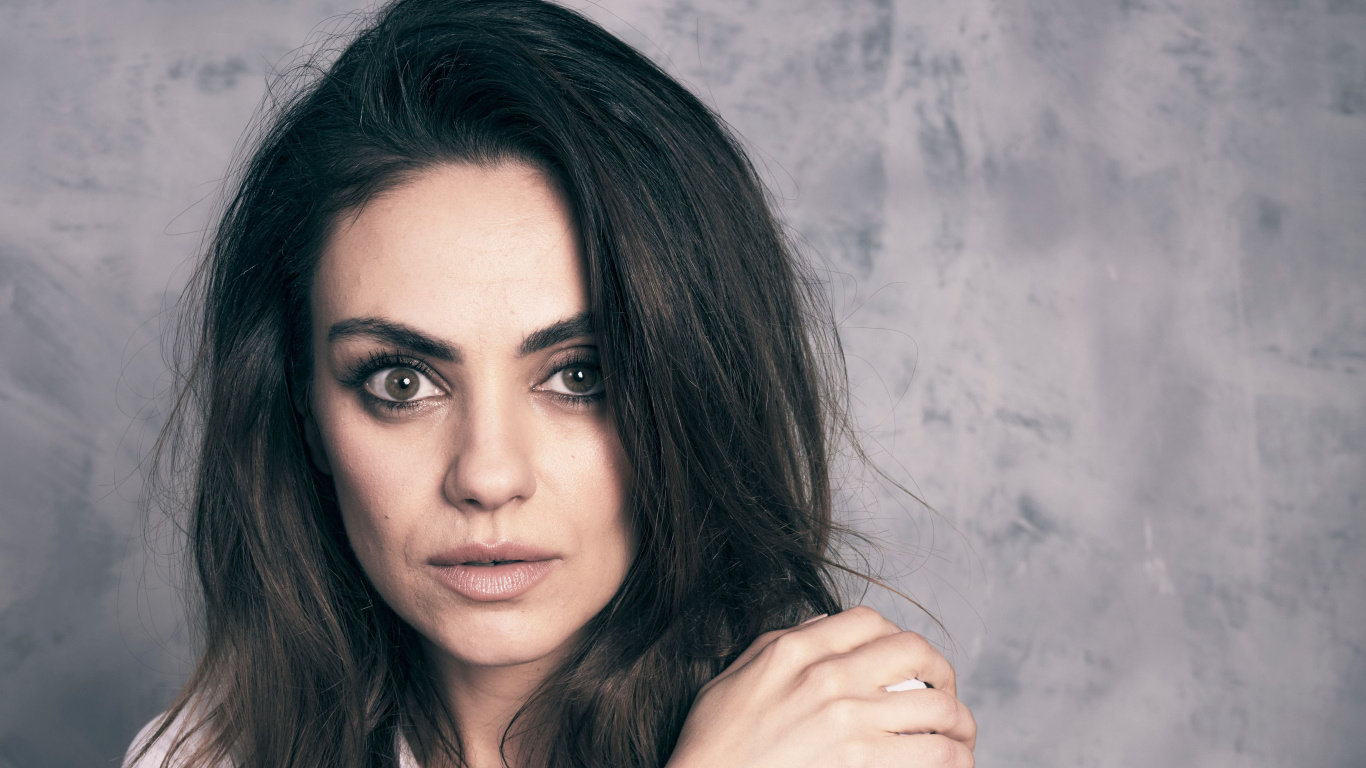 Американская актриса Мила Кунис на сером фоне