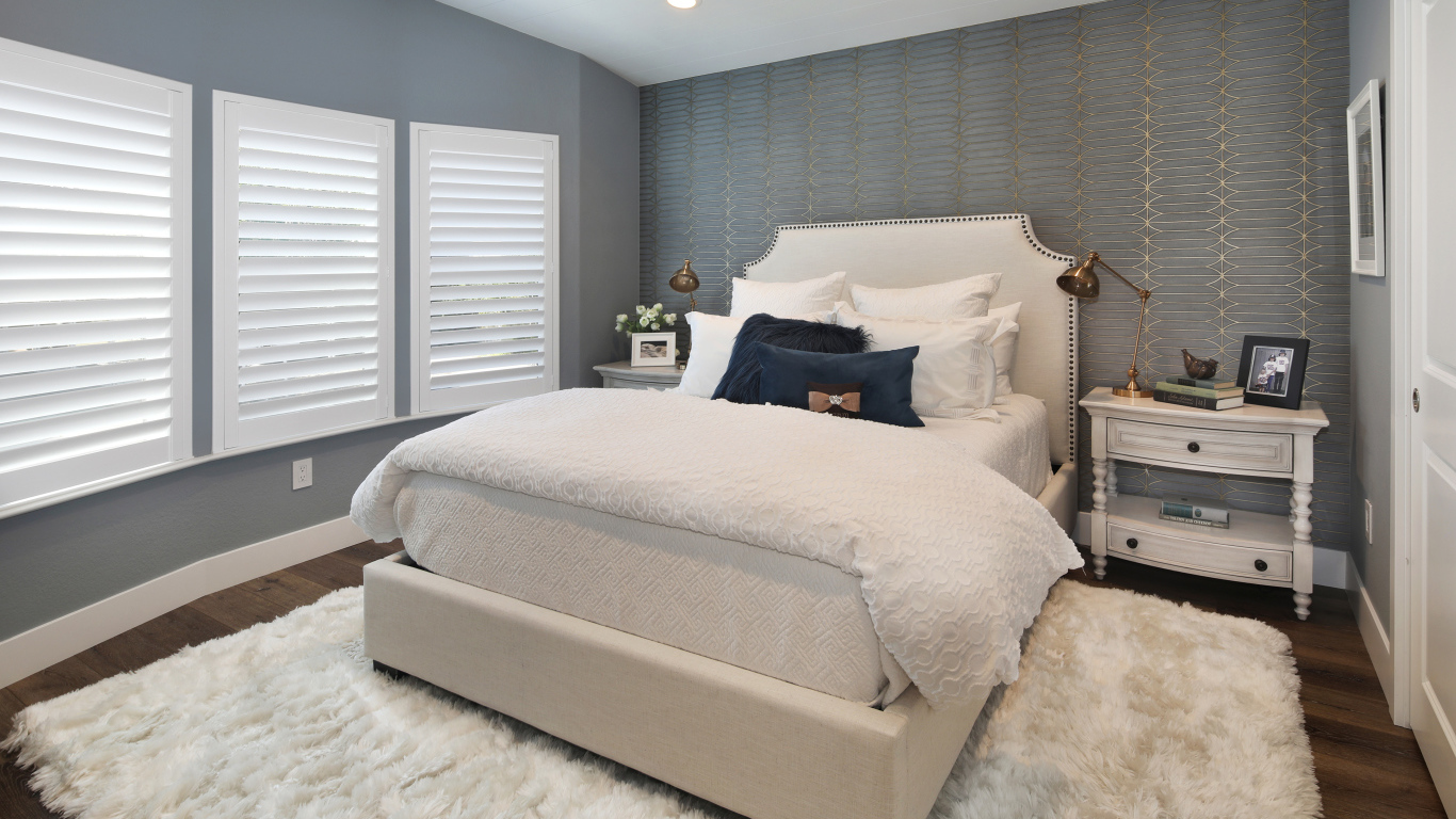 Высокая кровать в спальной комнате в серых тонах