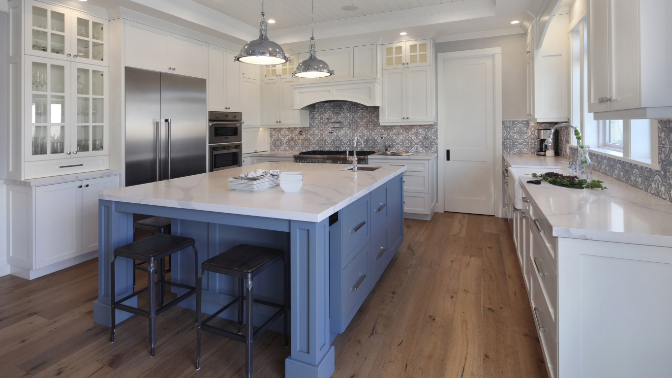 Большой серый стол в просторной белой кухне 