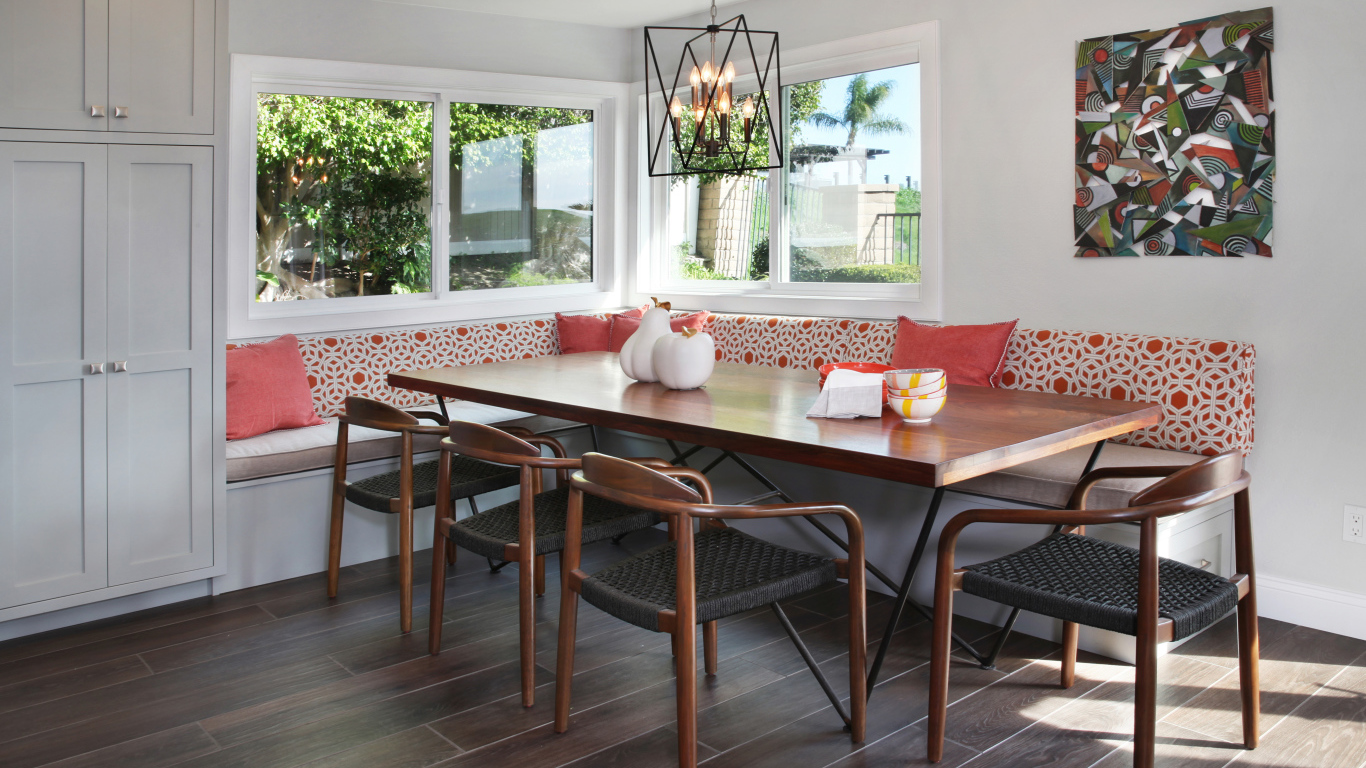 Большой деревянный стол и диван у окна в гостиной 