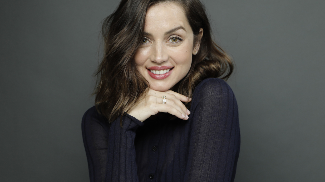 Улыбающаяся актриса Ана де Армас на сером фоне