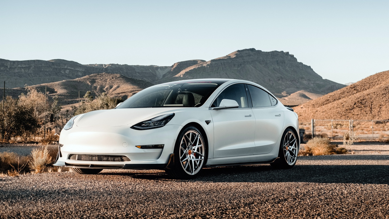 Белый автомобиль Tesla Model 3 Volta 2019 года на фоне гор 