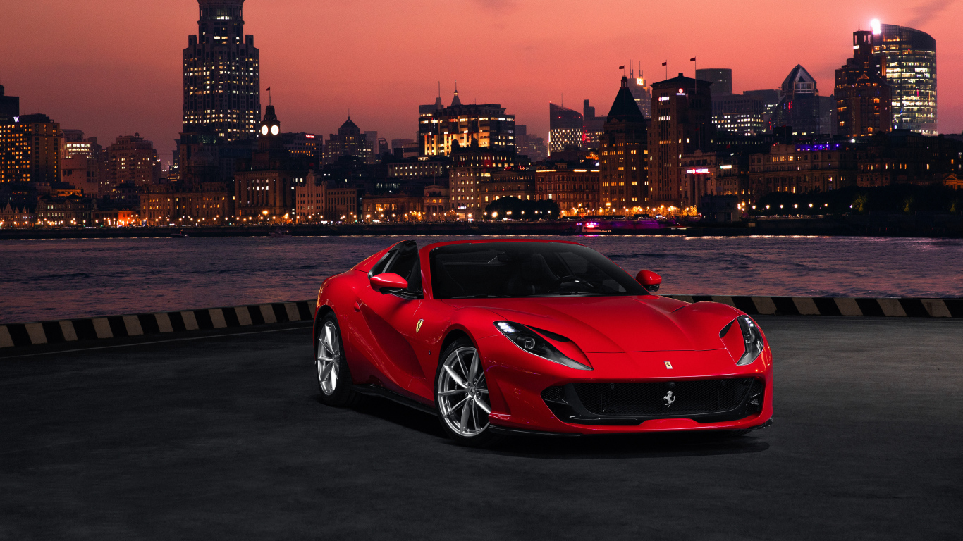 Красный автомобиль Ferrari 812 GTS  на фоне ночного города