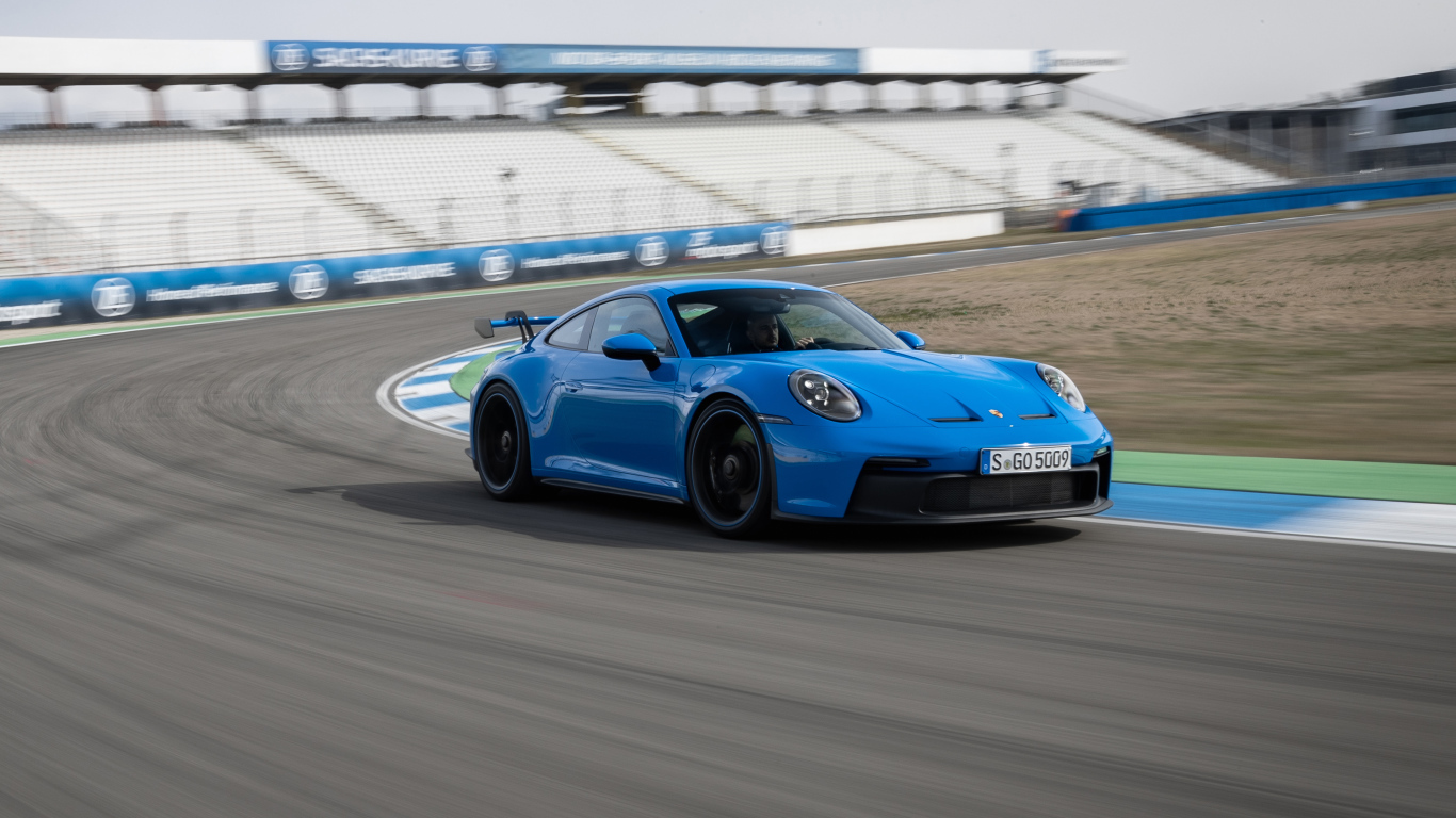 Голубой автомобиль Porsche 911 GT3 2021 года на стадионе