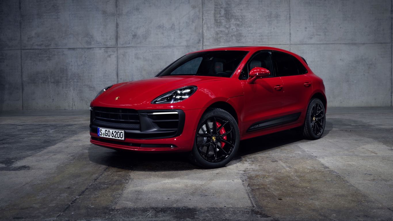 Красный автомобиль Porsche Macan GTS 2021 года на сером фоне