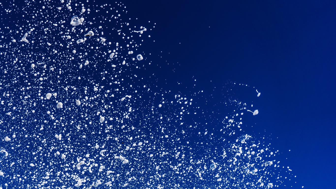 Белые брызги воды на синем фоне 