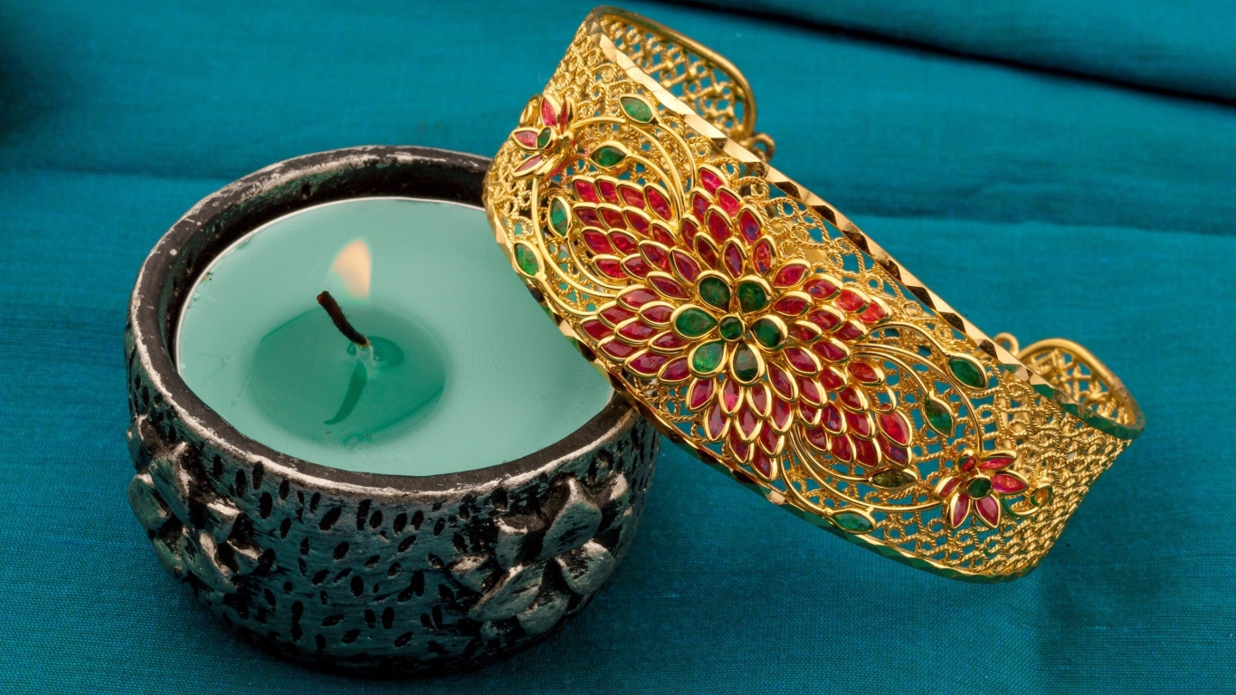 Красивый браслет со свечой на синем покрывале 