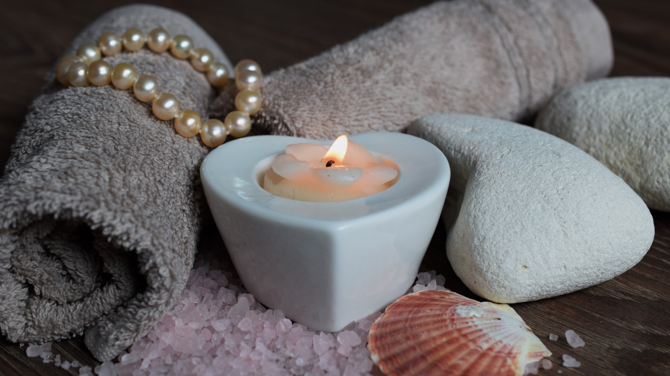 Красивая свеча с полотенцем, бусами, камнями и морской солью