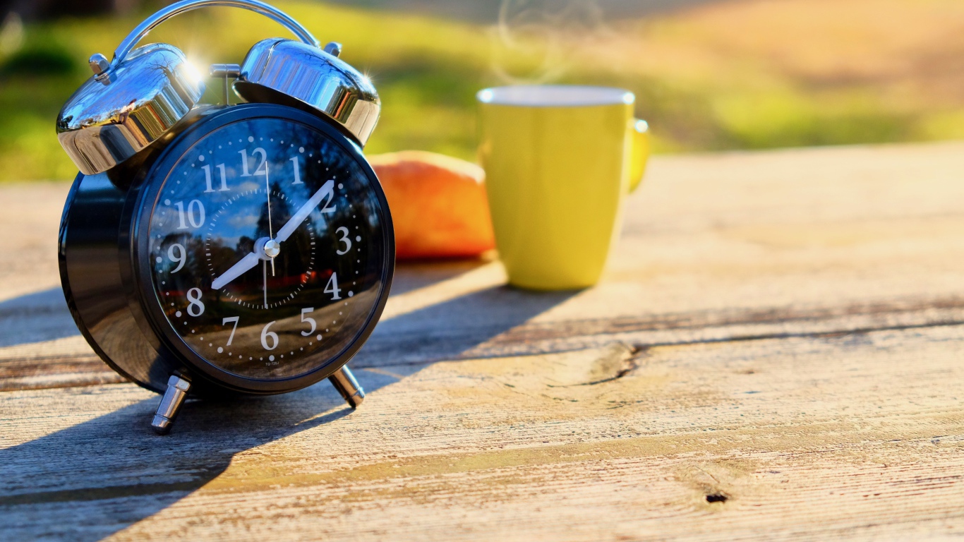 Большой черный будильник на столе