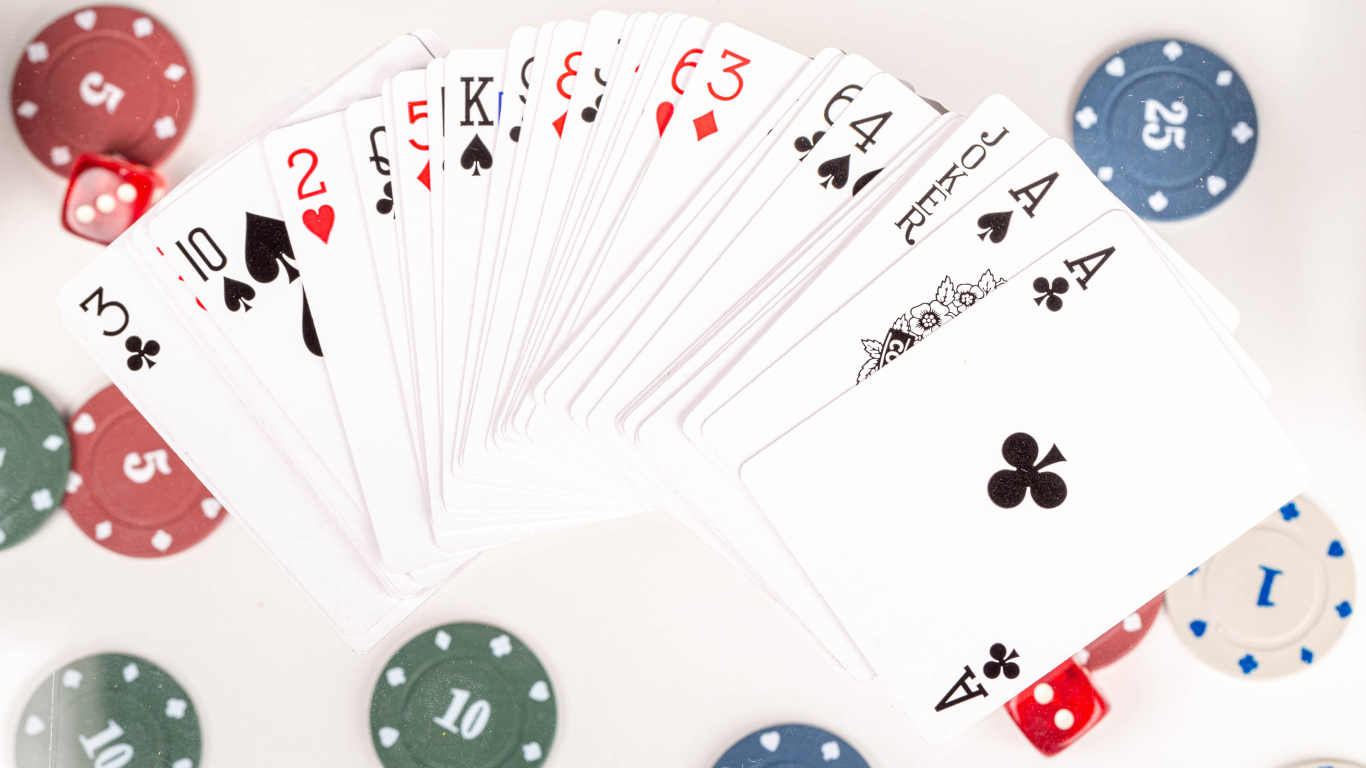 Колода игральных карт и фишки на столе в казино 