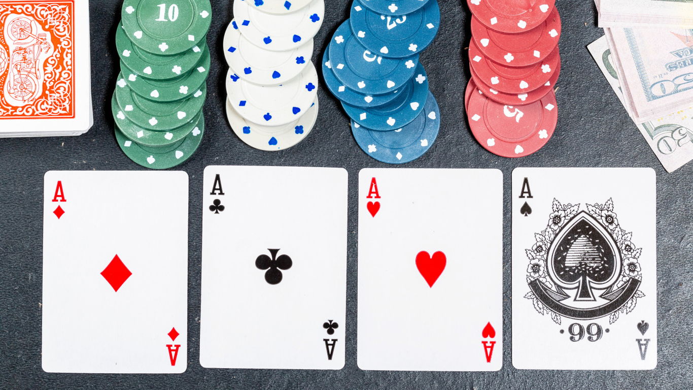 Четыре туза с фишками на сером столе