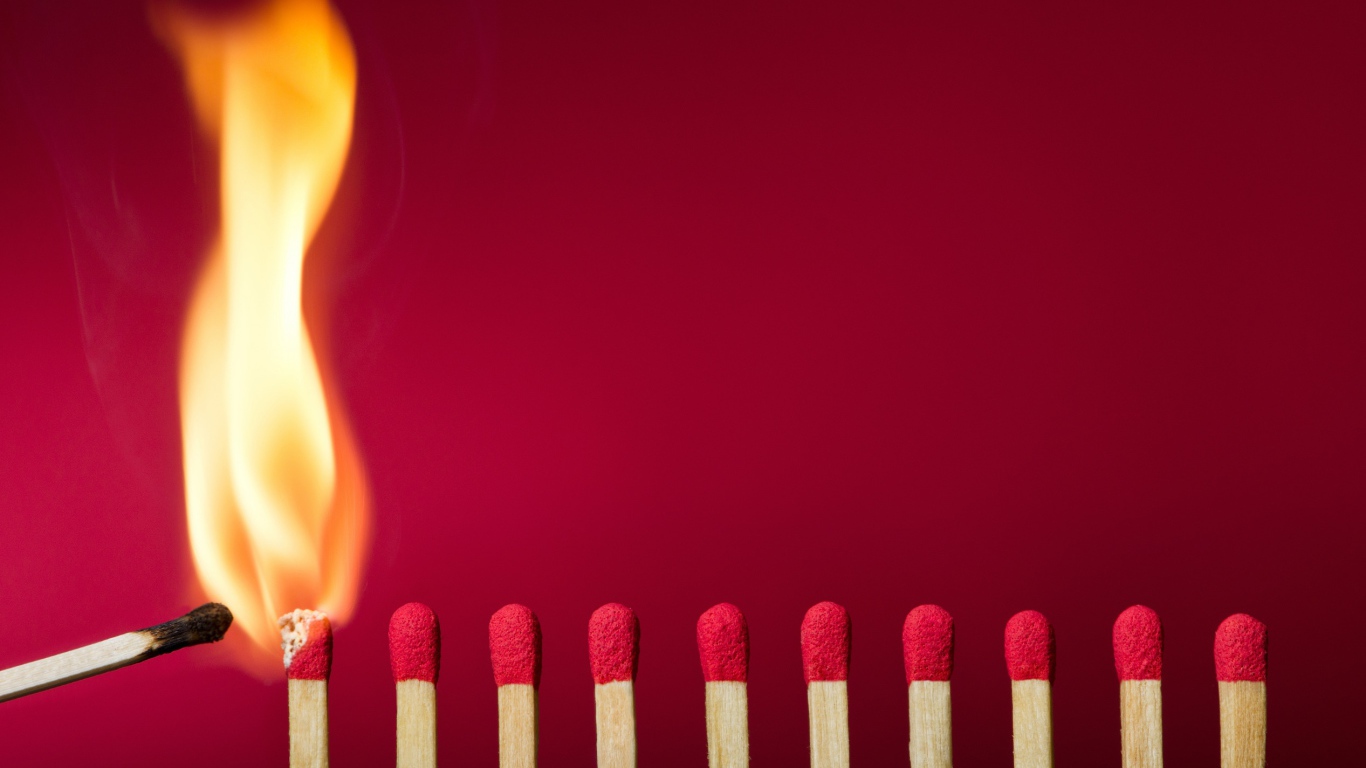 Спички поджигают на красном фоне