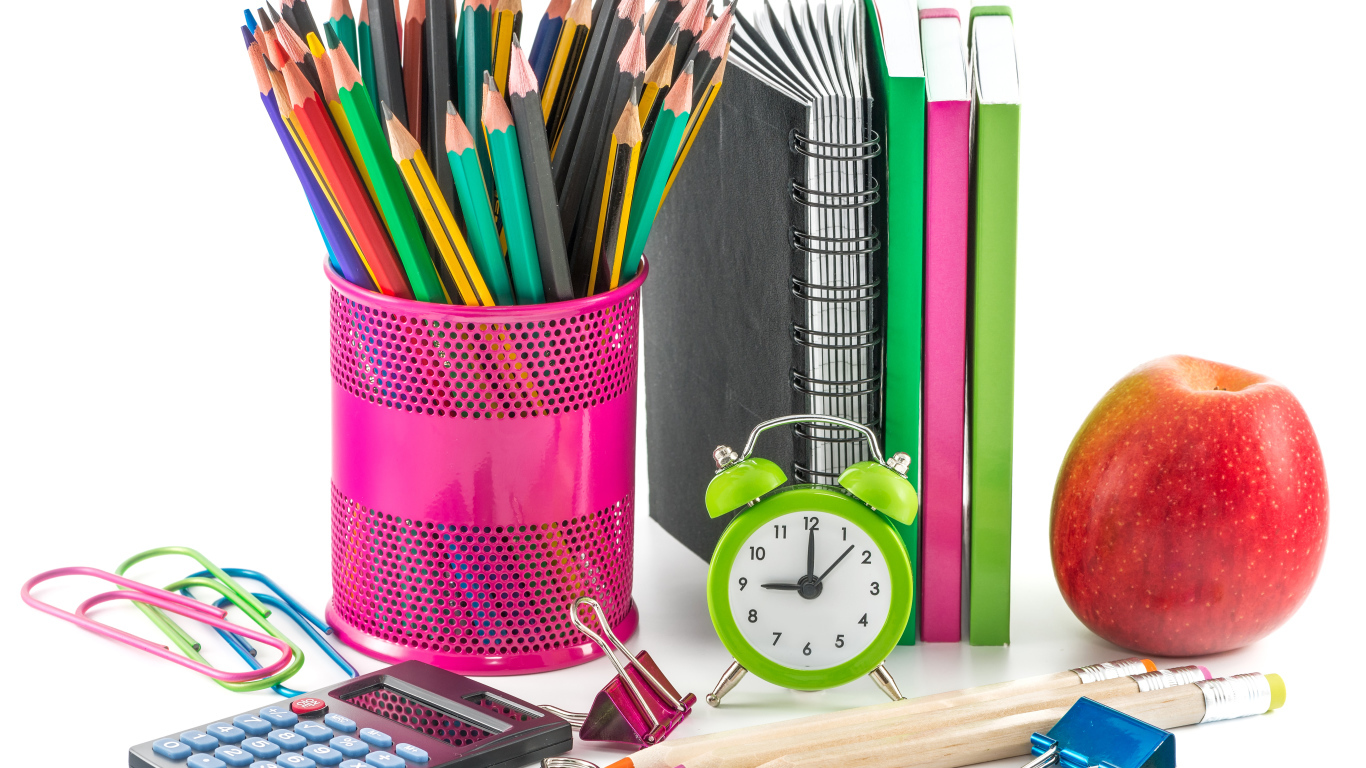 Карандаши, блокноты, часы и яблоко на белом фоне