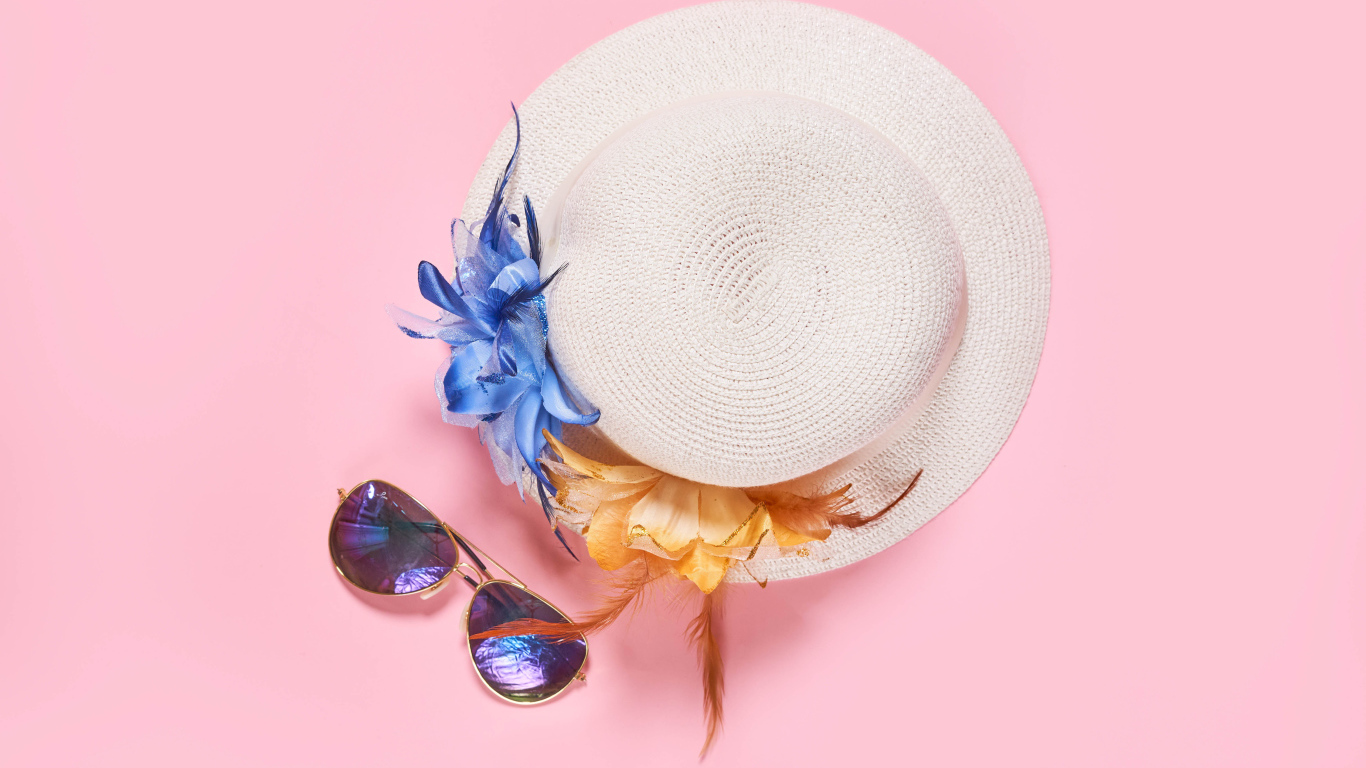 Straw hat with glasses on pink background