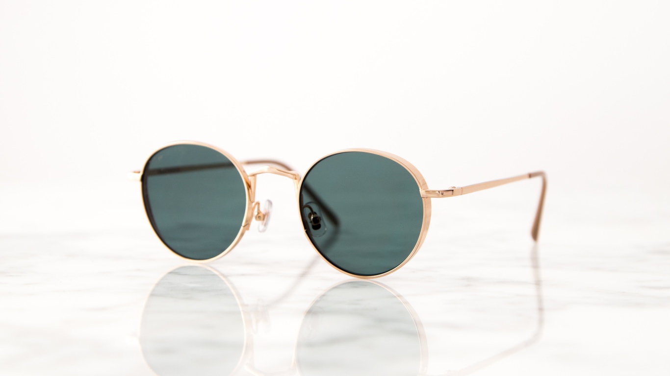 Солнечные очки лежат на зеркальной поверхности