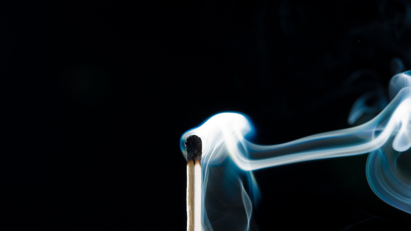 Белый дым от сожженной спички на черном фоне