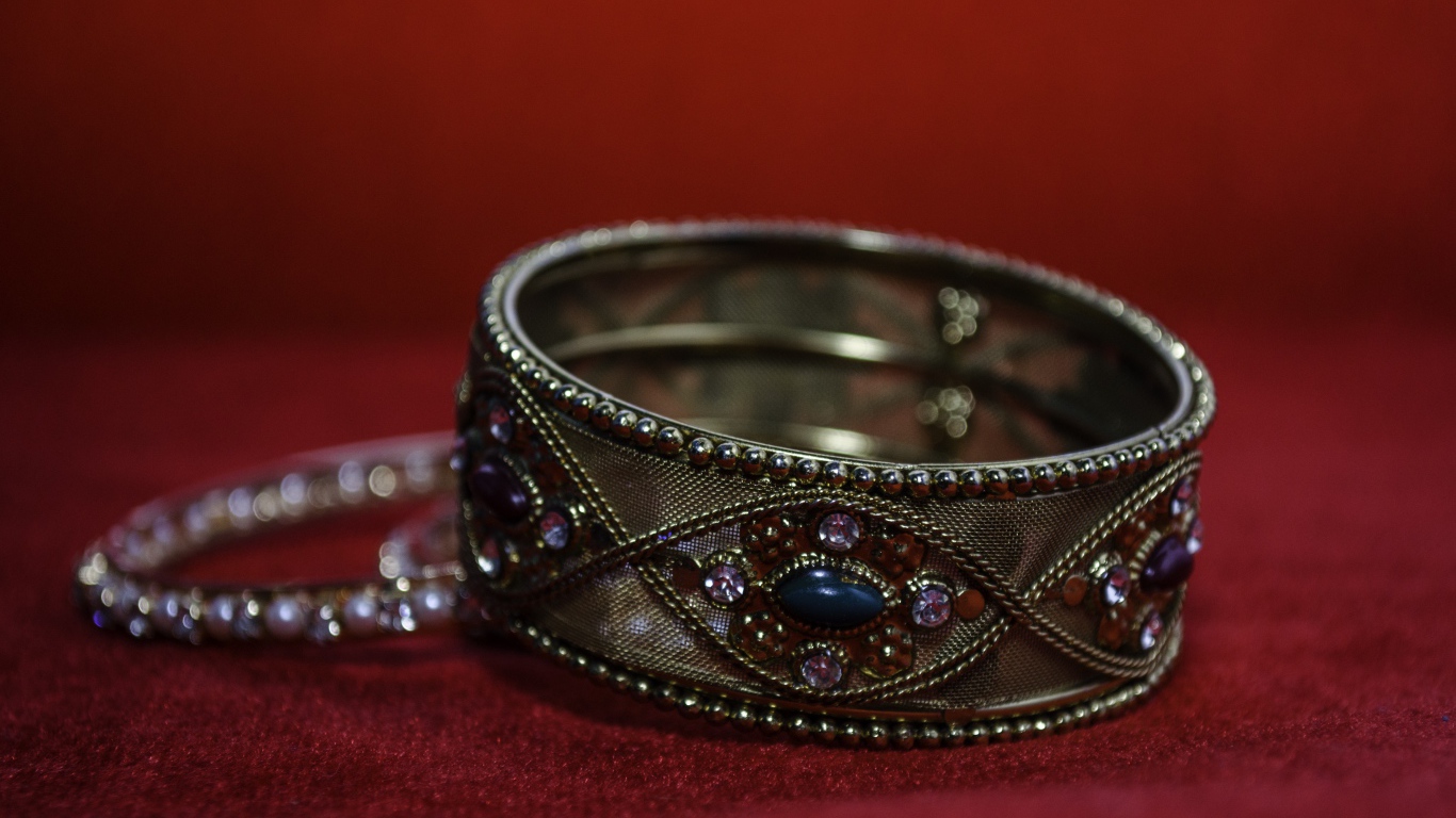 Красивый браслет с драгоценными камнями на красном фоне 