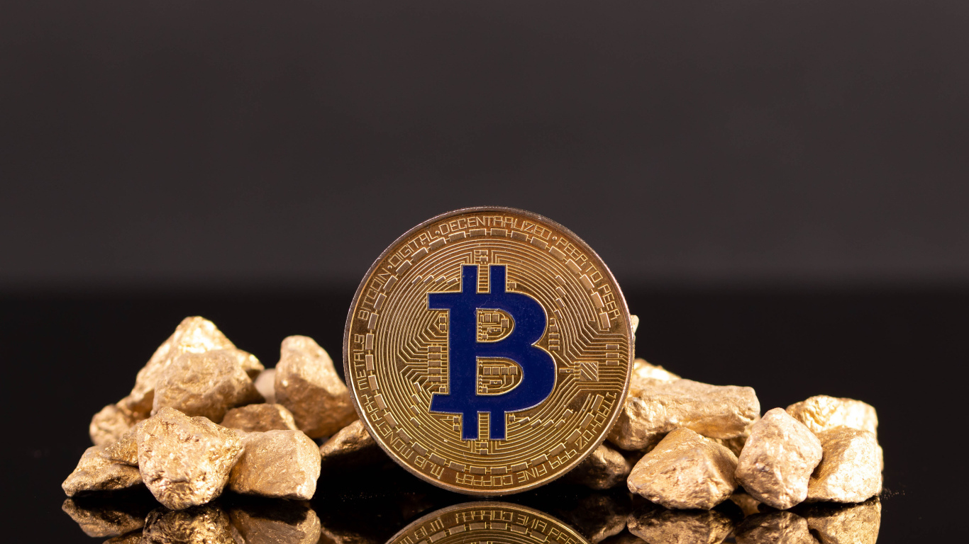 Монета биткоин с кусками золота на сером фоне