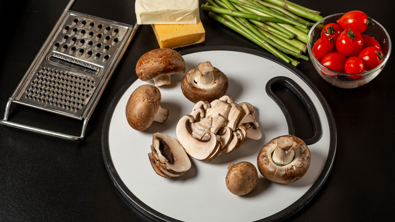 Шампиньоны на столе со спаржей и помидорами 