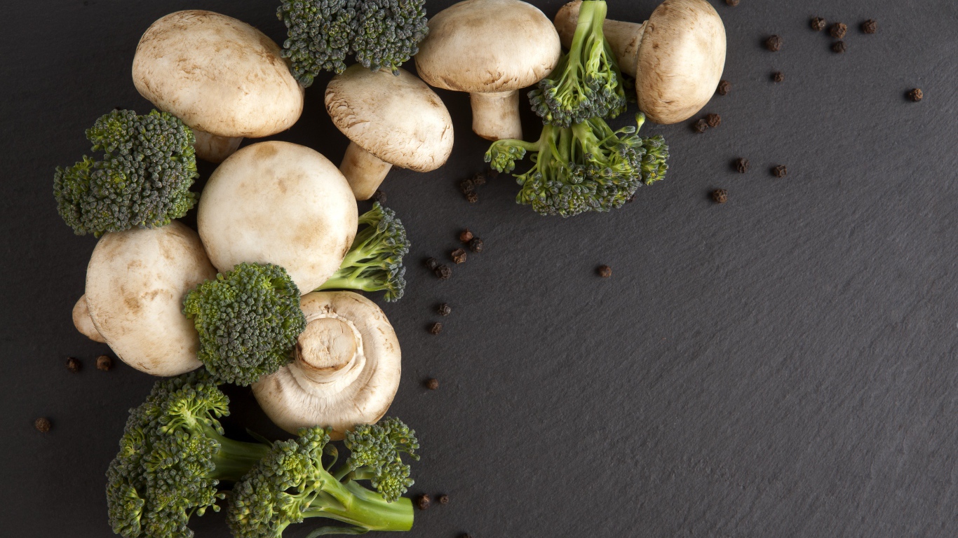 Шампиньоны с брокколи на сером столе 