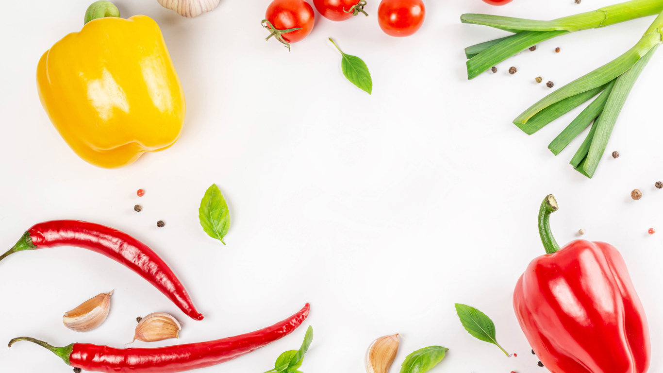 Разный перец на белом фоне с чесноком и помидорами