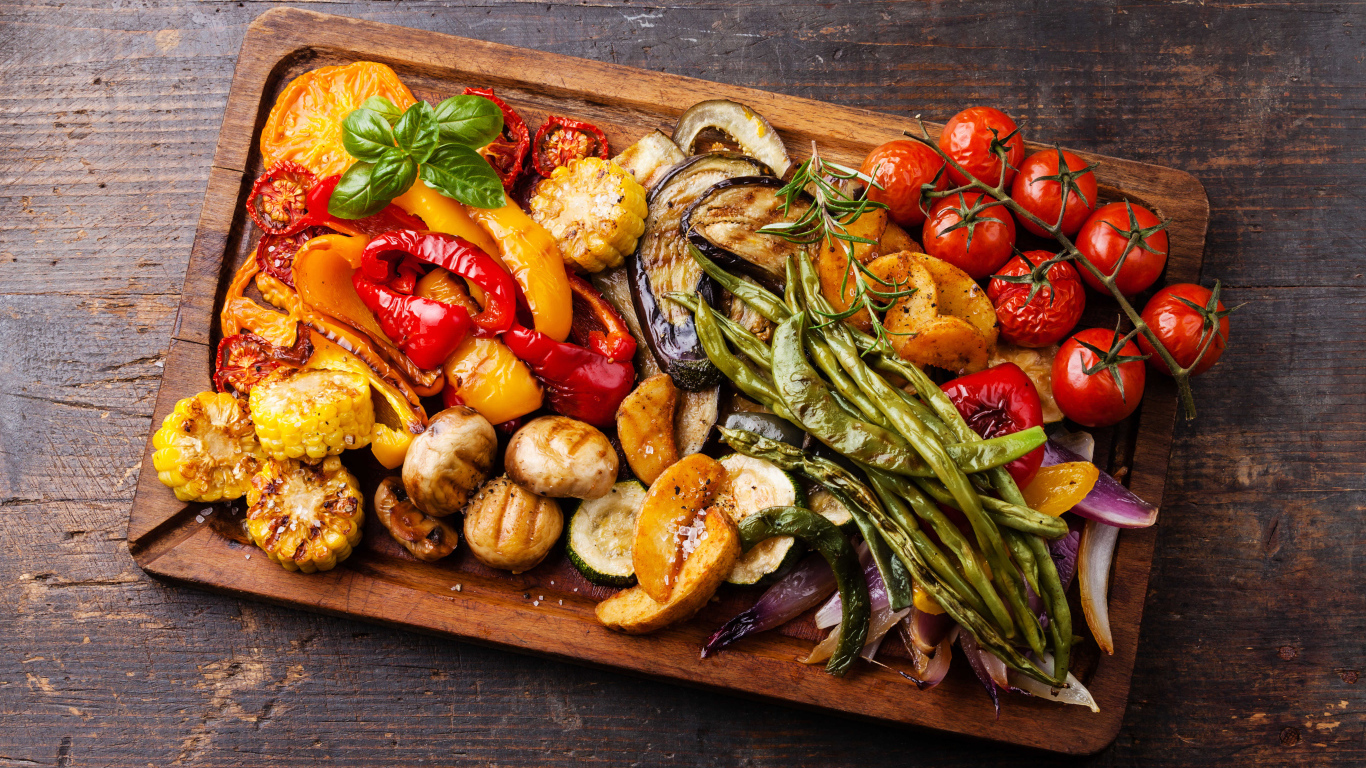 Запеченные на гриле овощи на разделочной доске 