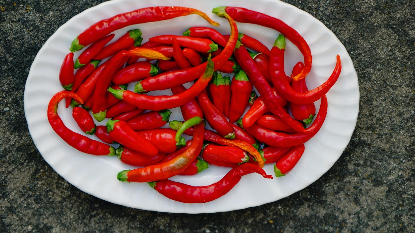Острый красный перец чили на большой белой тарелке