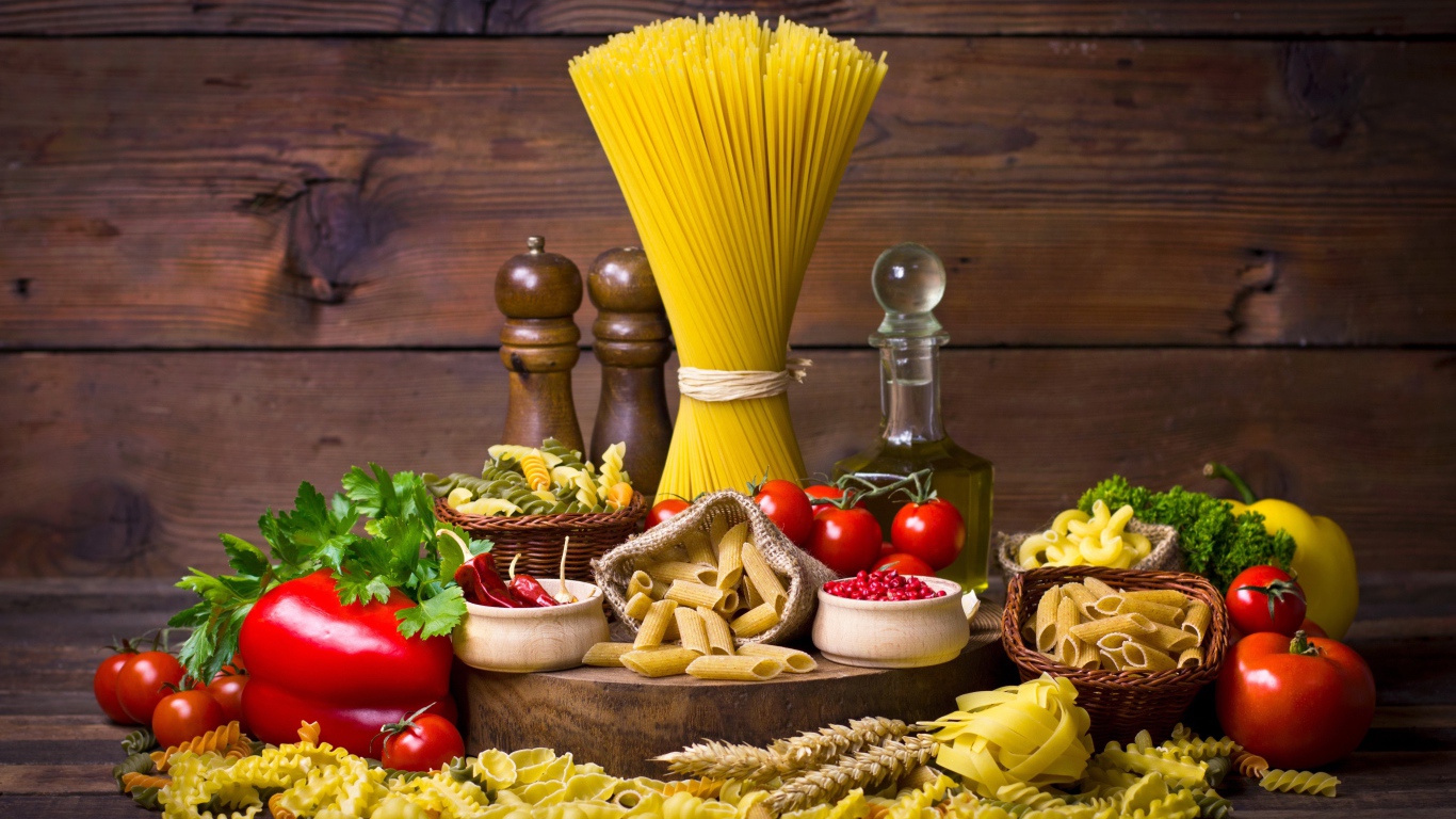 Много макаронных изделий на столе с овощами 