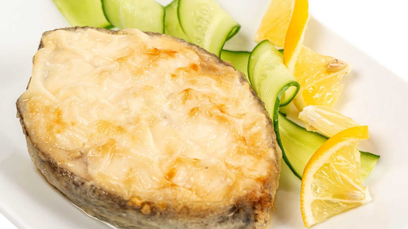 Картофель с сыром на тарелке с огурцами и лимоном 