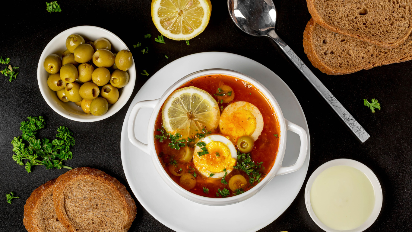 Солянка на столе  с хлебом и оливками 