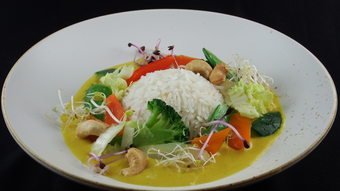 Вареный рис с овощами в большой белой тарелке