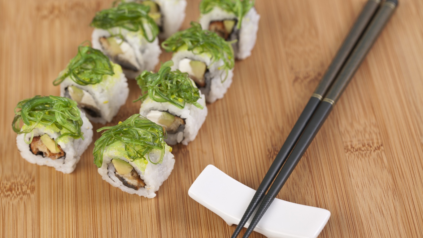 Суши с черными палочками на столе
