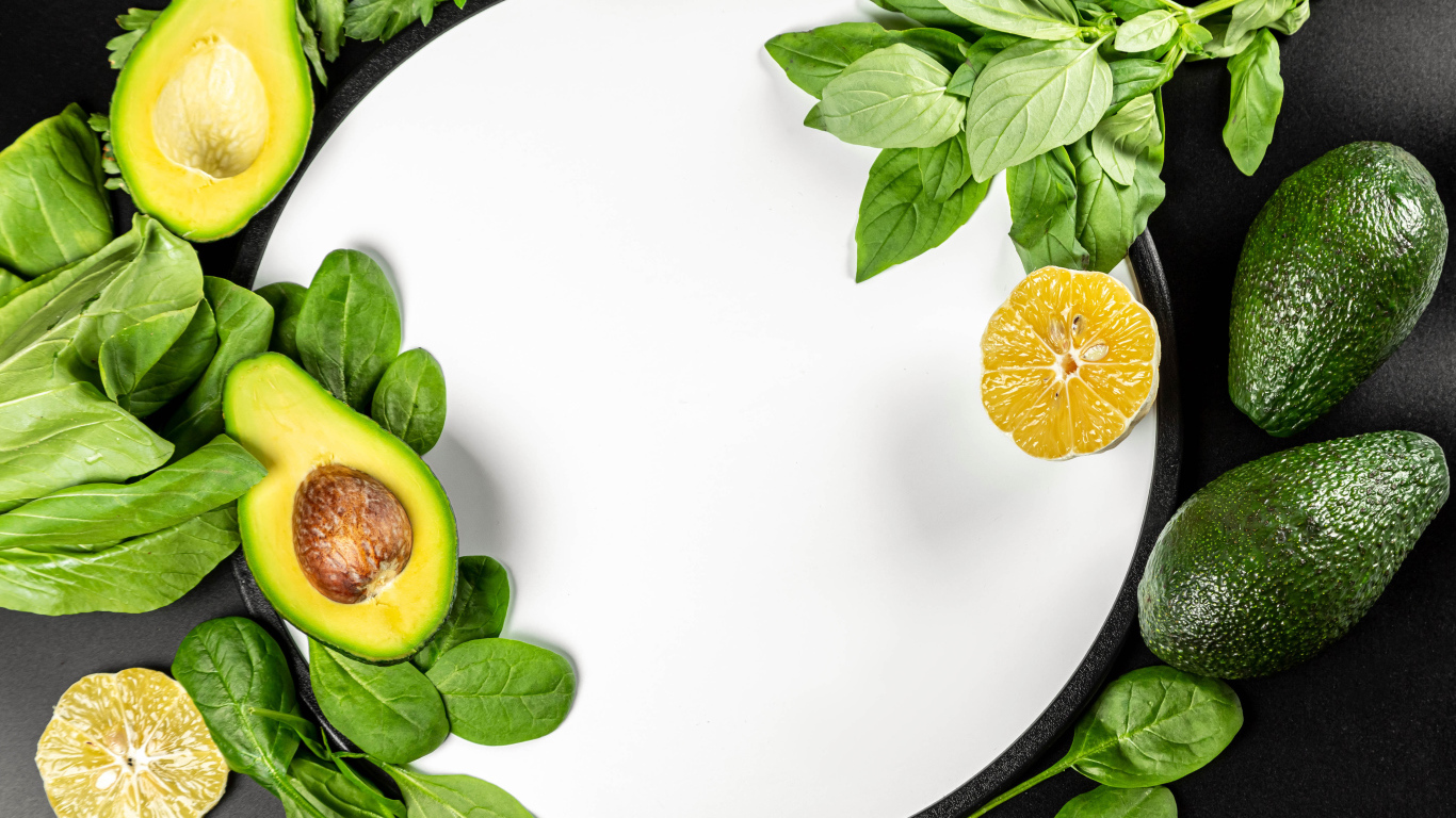 Авокадо с листьями базилика на белом фоне