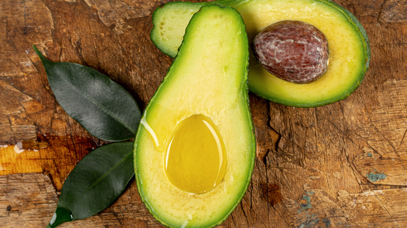 Зеленое авокадо на деревянном столе