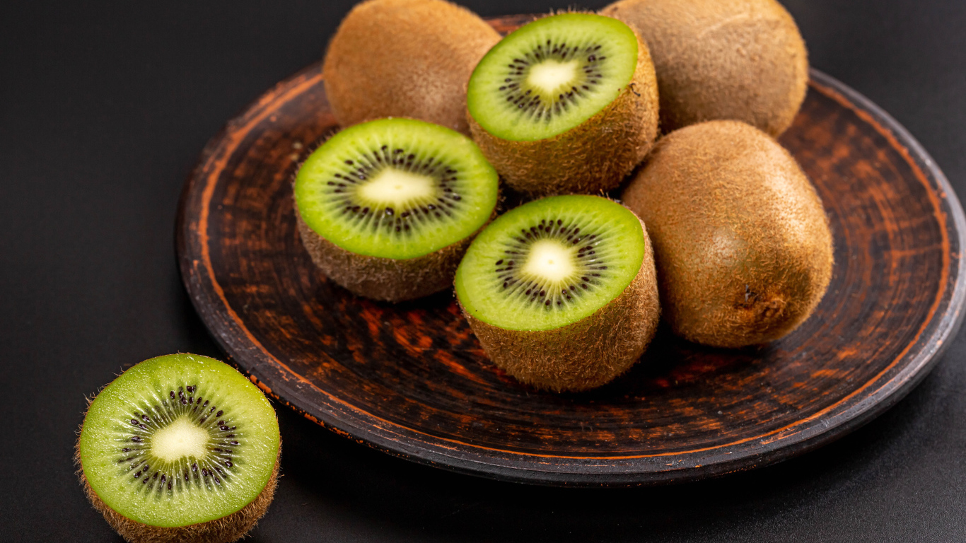 Зеленое киви на большой тарелке на столе