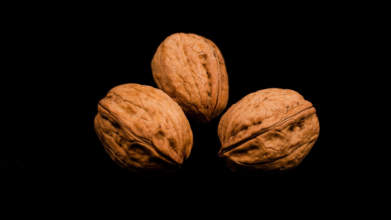Три грецких ореха на черном фоне 