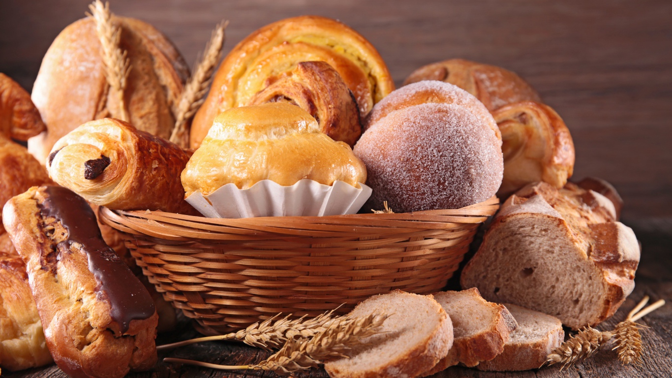 Свежая аппетитная выпечка в корзине на столе 