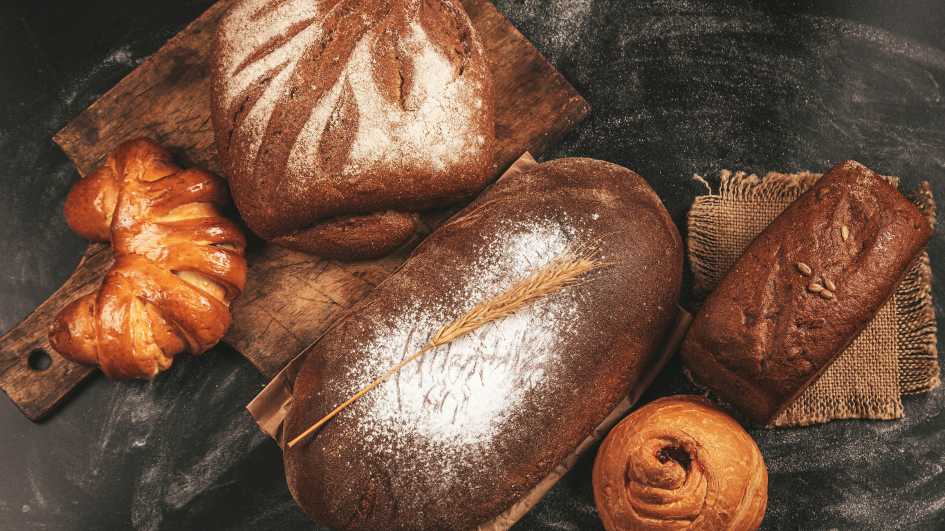 Свежий хлеб и булочки на разделочной доске