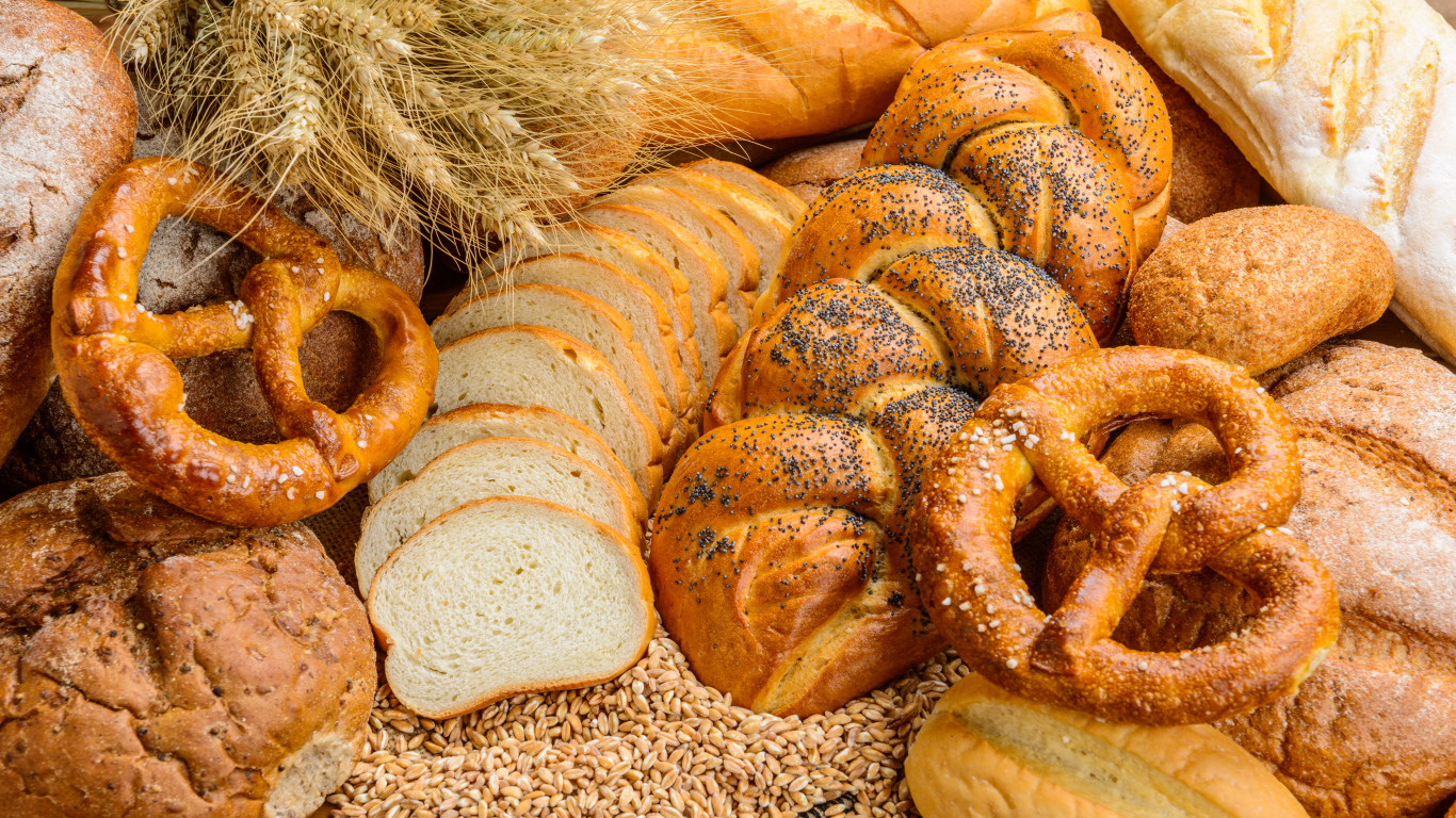 Свежая выпечка на столе с колосьями и зернами пшеницы 