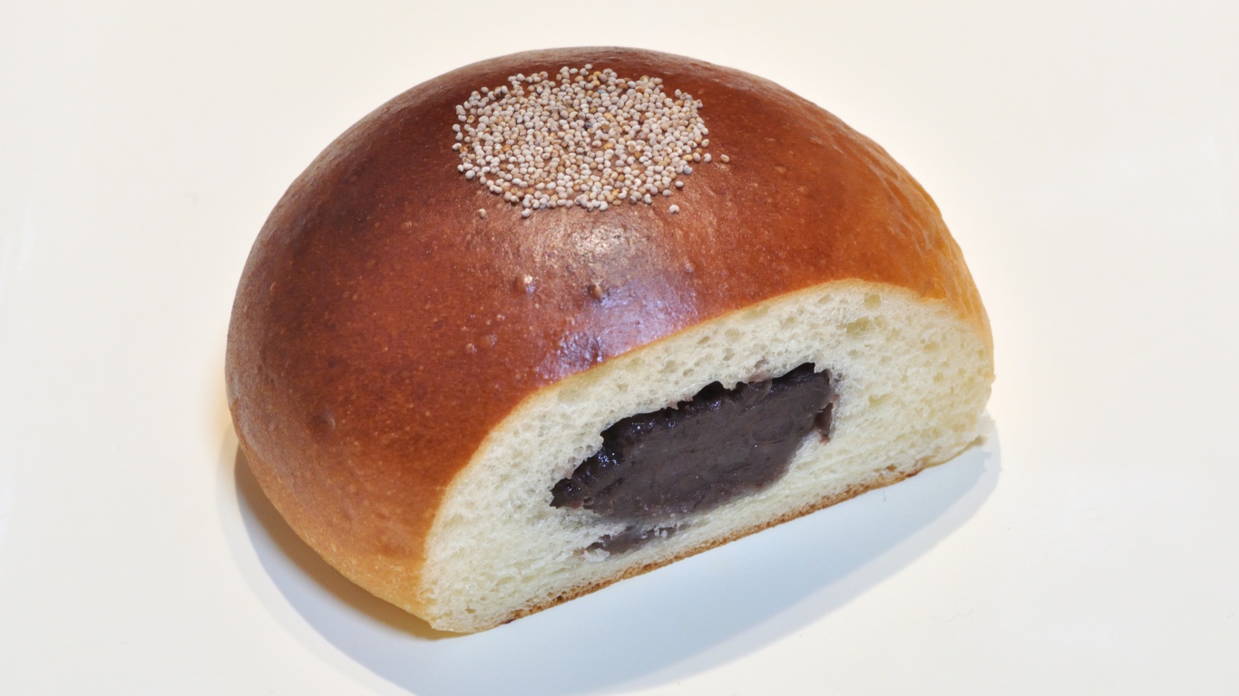 Свежая румяная булочка с вареньем на белом фоне