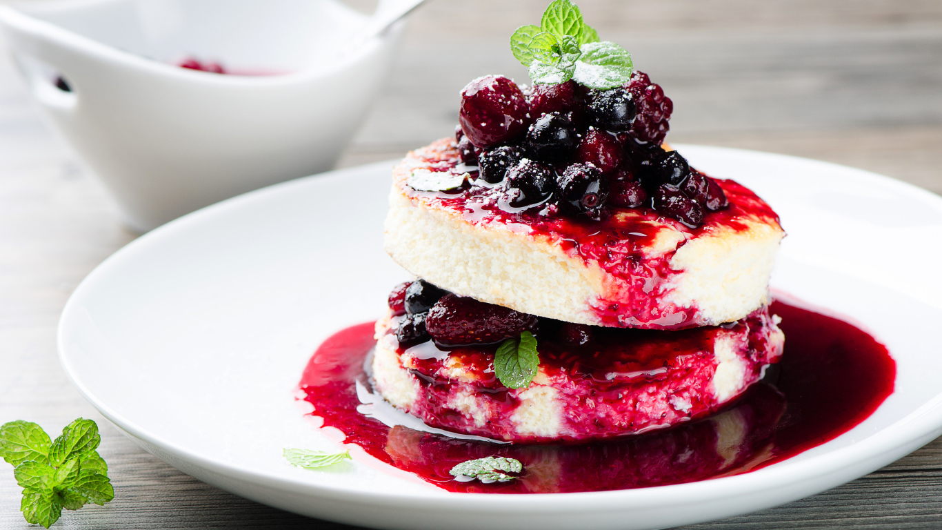 Аппетитные сырники с ягодами на белой тарелке 