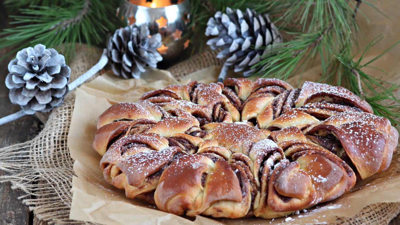 Сдобный венок с вареньем на столе с шишками