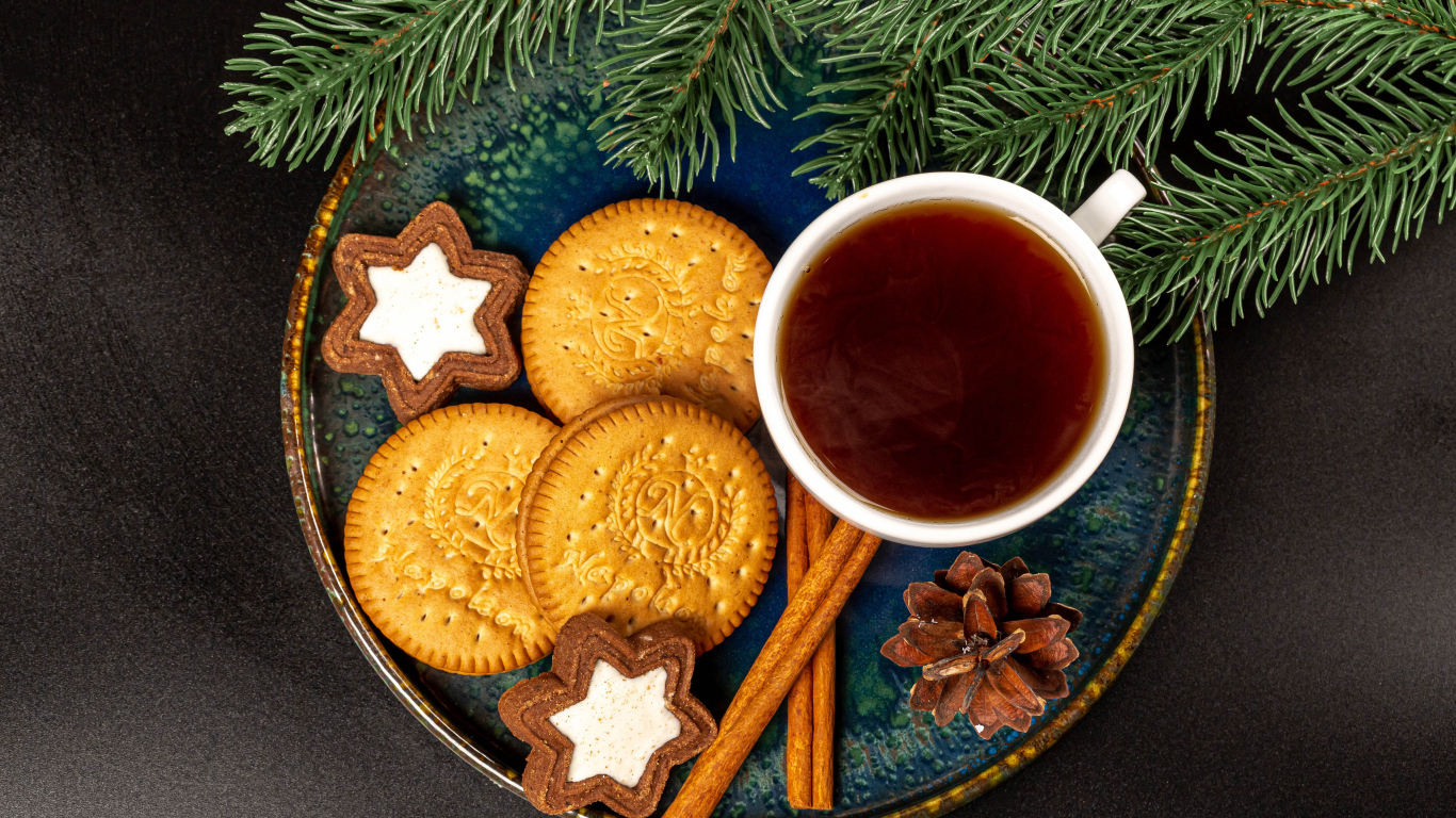 Печенье, чай и корица на столе с еловой веткой