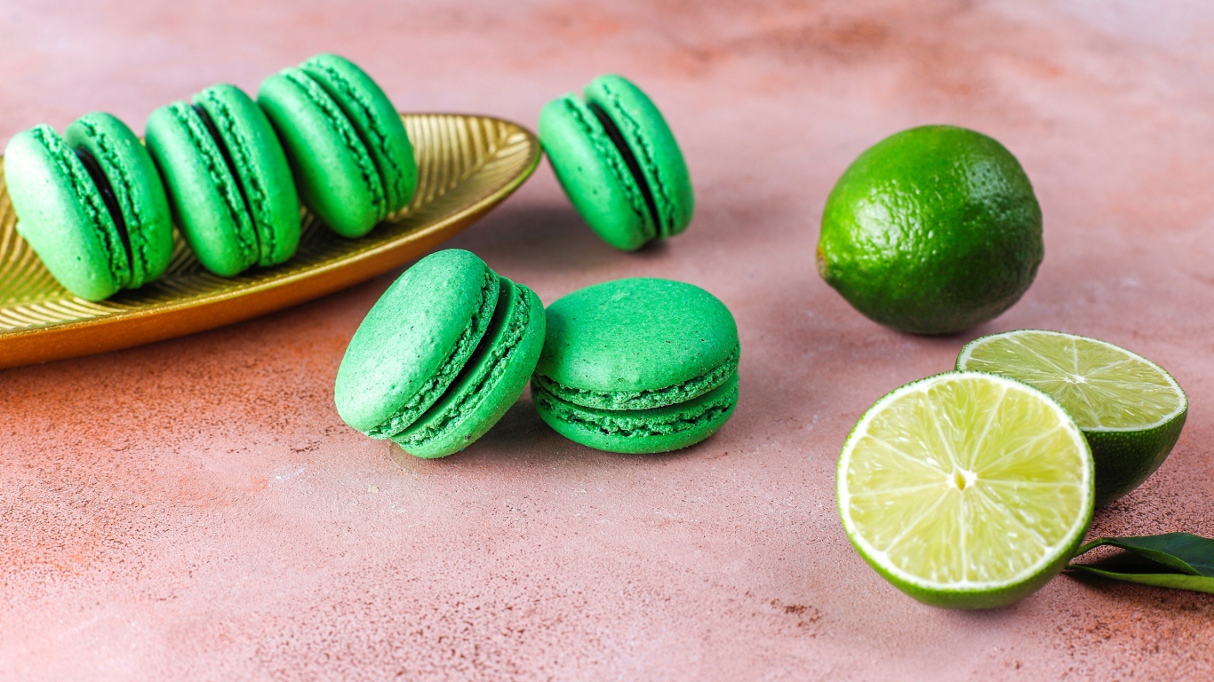 Зеленый десерт макарун на столе с лаймом